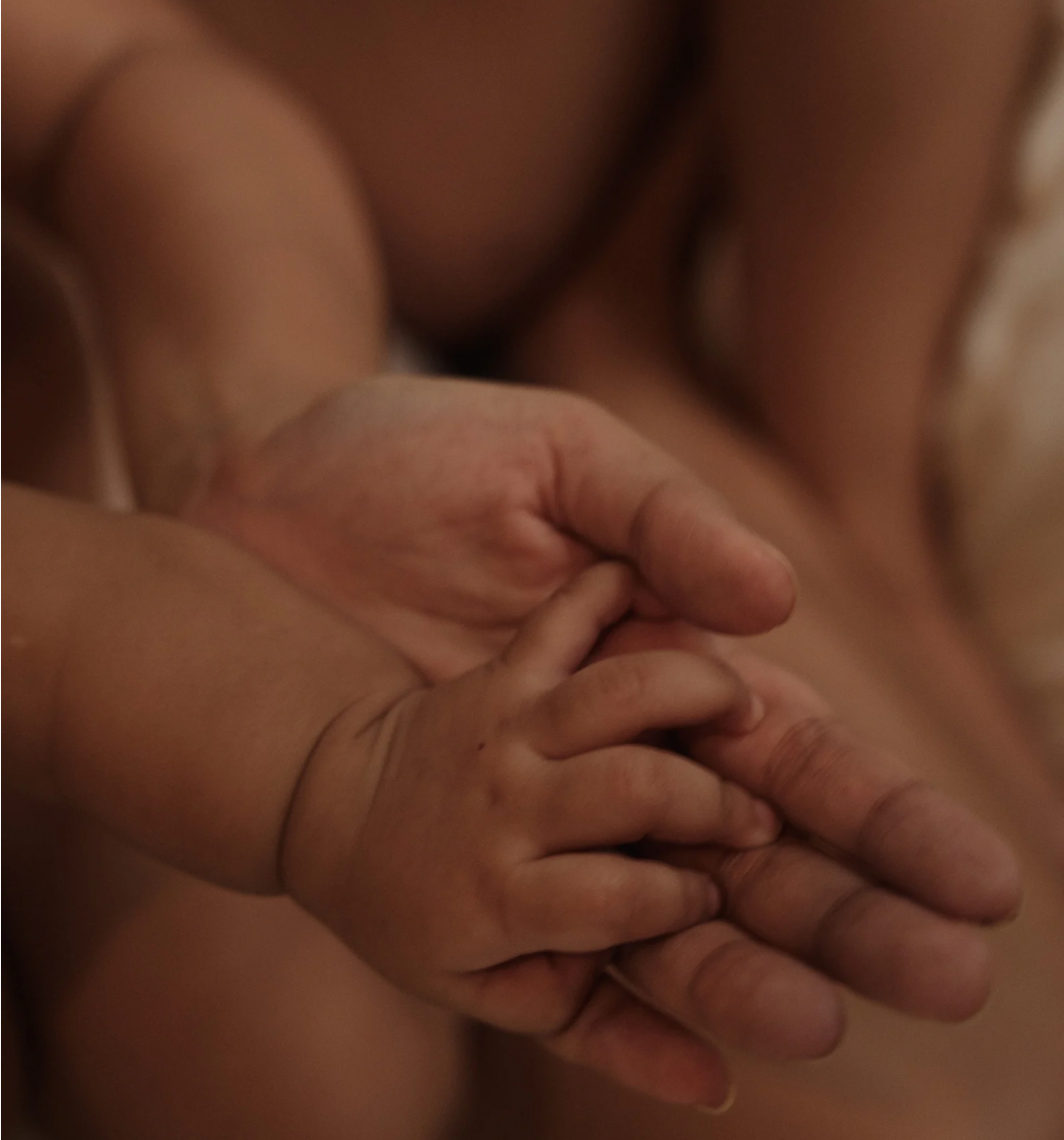 Mutter hält Babys Hand für Babyyoga in Aurich, Ostfriesland